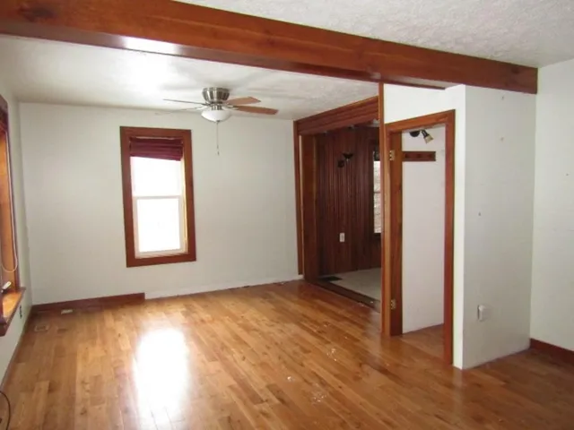 an empty room with wooden floor and a window