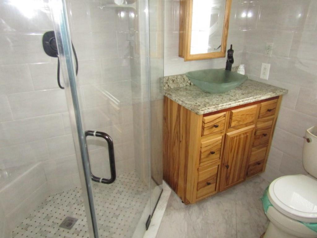 761 Highway 18 Burgettstown, PA 15021 - Photo 21 of 27 a bathroom with a granite countertop sink a toilet and a shower