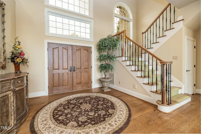 a view of a dining room and livingroom with furniture wooden floor a chandelier