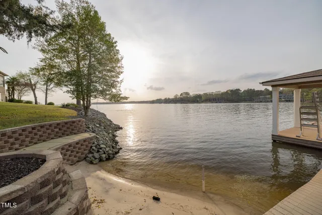 a front view of a house with a yard and large trees