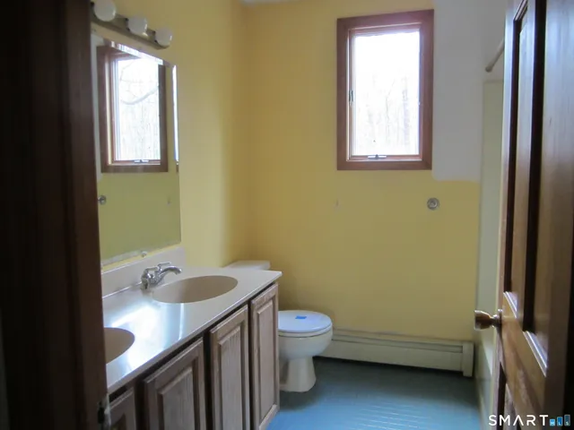 a bathroom with a sink toilet and window