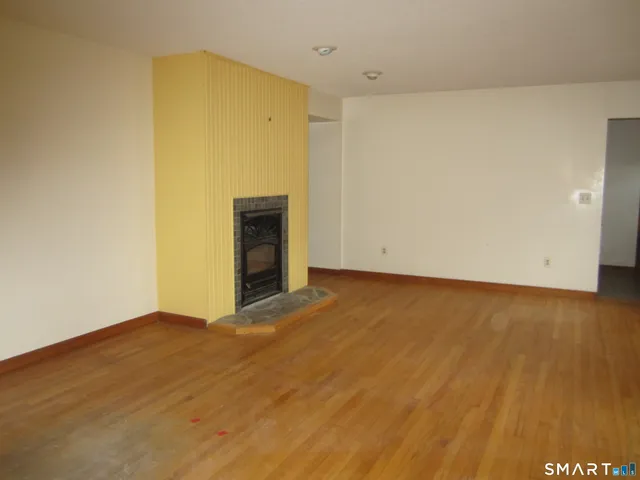 an empty room with wooden floor and cabinet