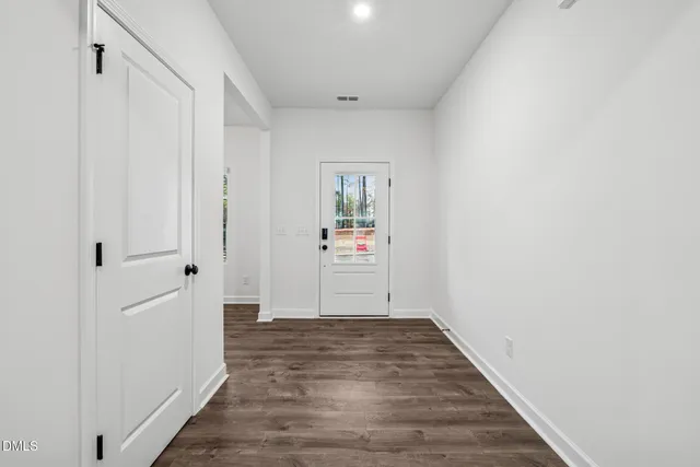 a view of a hallway with wooden floor and closet
