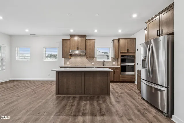 a kitchen with kitchen island a counter top space stainless steel appliances and cabinets