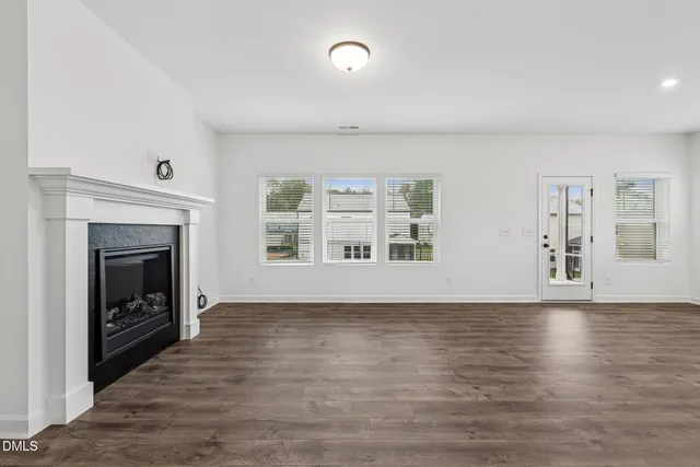 a view of an empty room with a window and fireplace