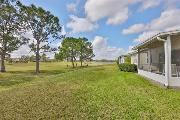 an aerial view of residential houses with outdoor space and lake view