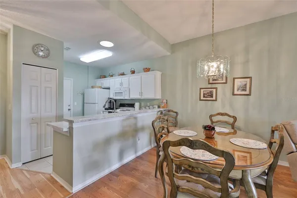 a view of a dining room with furniture a chandelier and wooden floor