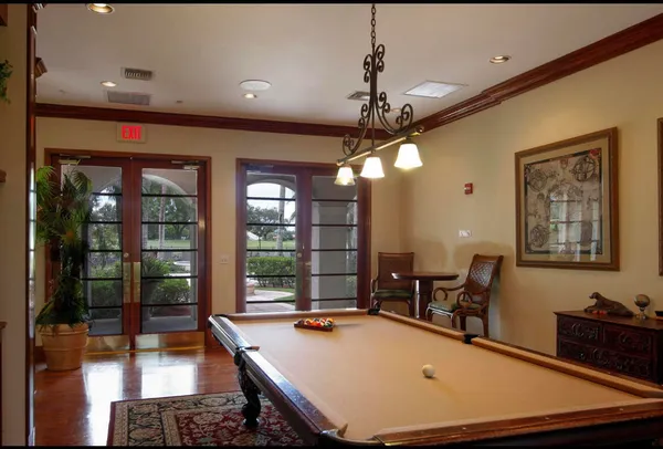 a room with pool table and windows