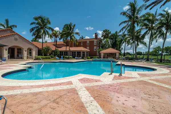 a view of swimming pool with outdoor seating and house in the background