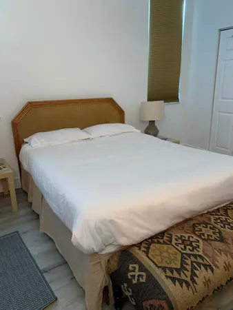 a bedroom with a bed and a lamp on the dresser