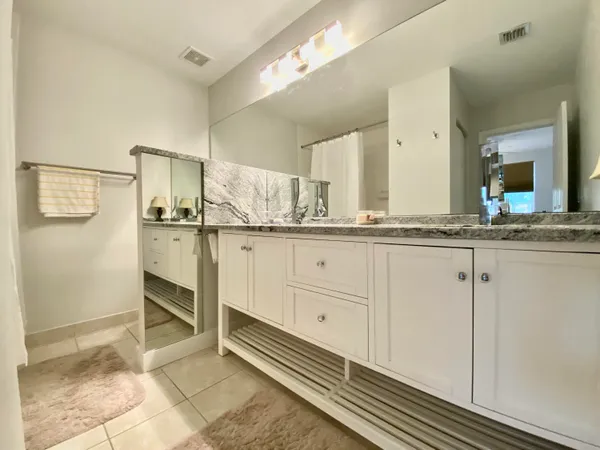 a bathroom with a granite countertop sink mirror and cabinets