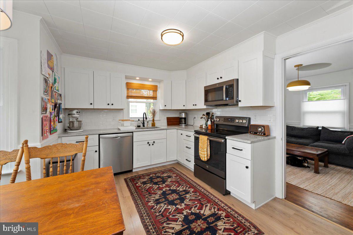1708 Wrightfield Road Yardley, PA 19067 - Photo 14 of 41 a kitchen with stainless steel appliances granite countertop a stove top oven a sink a dining table and chairs with wooden floor
