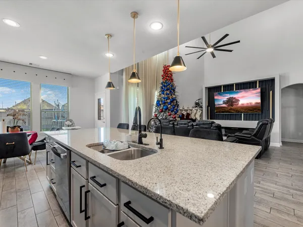 a kitchen with stainless steel appliances a sink a counter top space and living room view