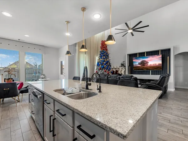 a kitchen with stainless steel appliances a sink a counter top space and living room view