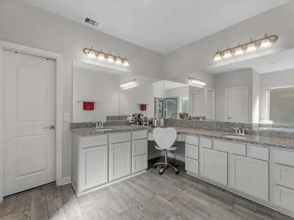 a large white kitchen with a sink cabinets and living room view