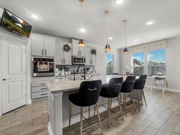 a view of kitchen with dining area refrigerator and wooden floor