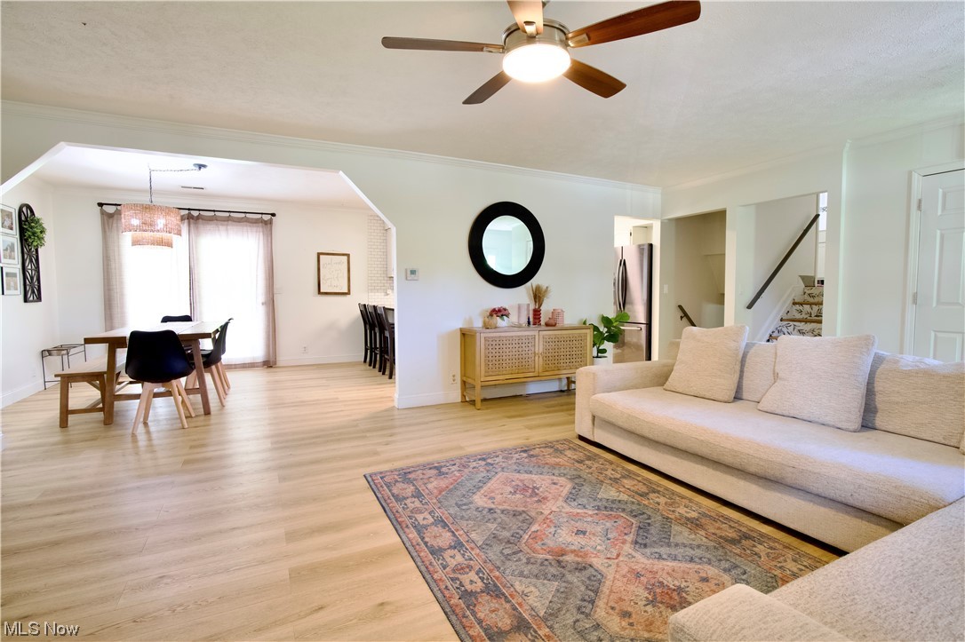 444 Eyermann Road Belpre, OH 45714 - Photo 2 of 16 Living room featuring ceiling fan, light hardwood / wood-style floors, and crown molding