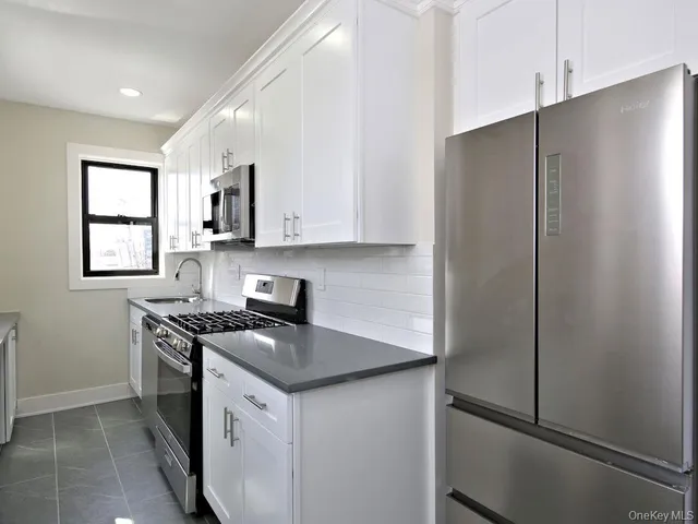 a kitchen with stainless steel appliances white cabinets and a refrigerator