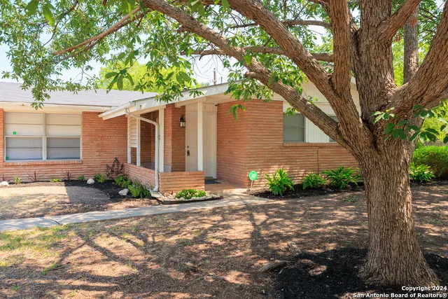 a front view of a house with a yard and potted plants