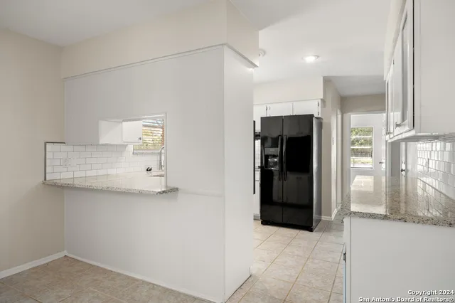 a view of kitchen with furniture and refrigerator