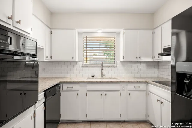 a kitchen with stainless steel appliances granite countertop a sink a stove and a microwave
