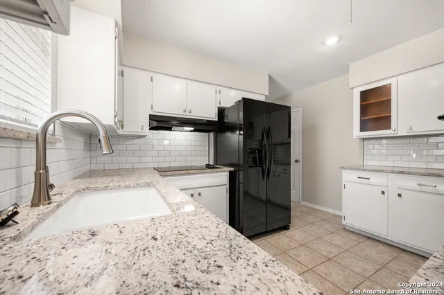 a kitchen with stainless steel appliances kitchen island granite countertop a refrigerator and a stove top oven