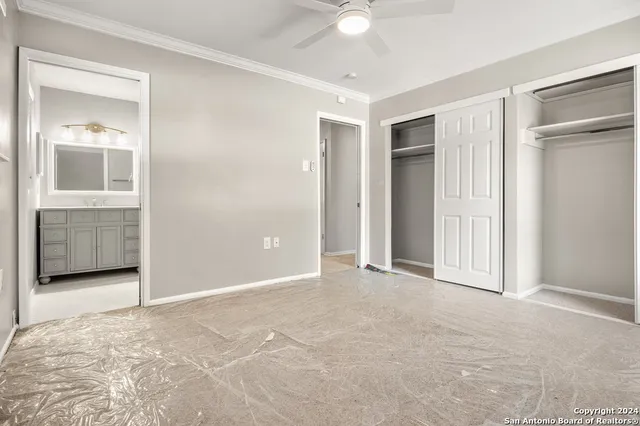 a view of an empty room with closet and bathroom