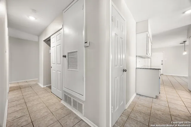 a view of a refrigerator in kitchen and an empty room