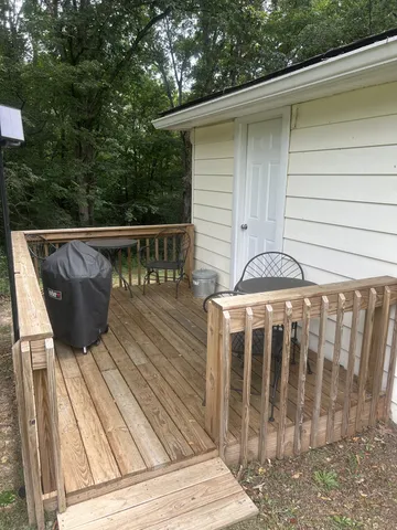 a view of balcony with wooden floor and fence