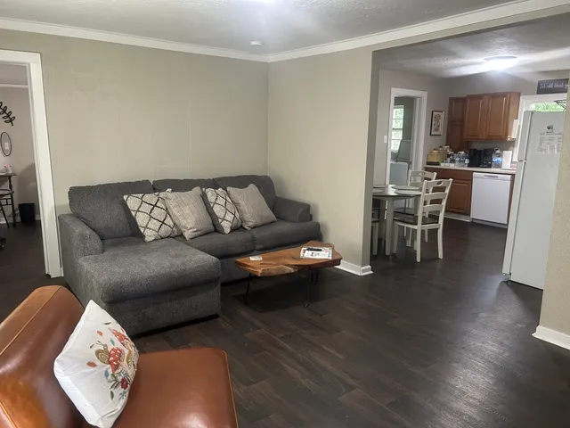 a living room with furniture and a wooden floor