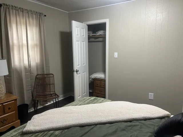 a bedroom with a bed and dresser with mirror