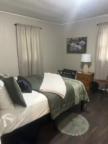 a bedroom with two beds and painting on the wall