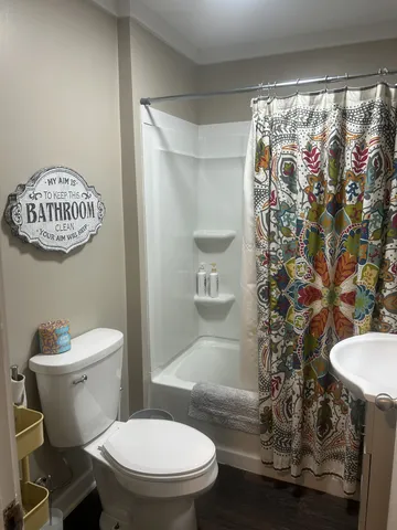 a bathroom with a toilet and a shower curtain