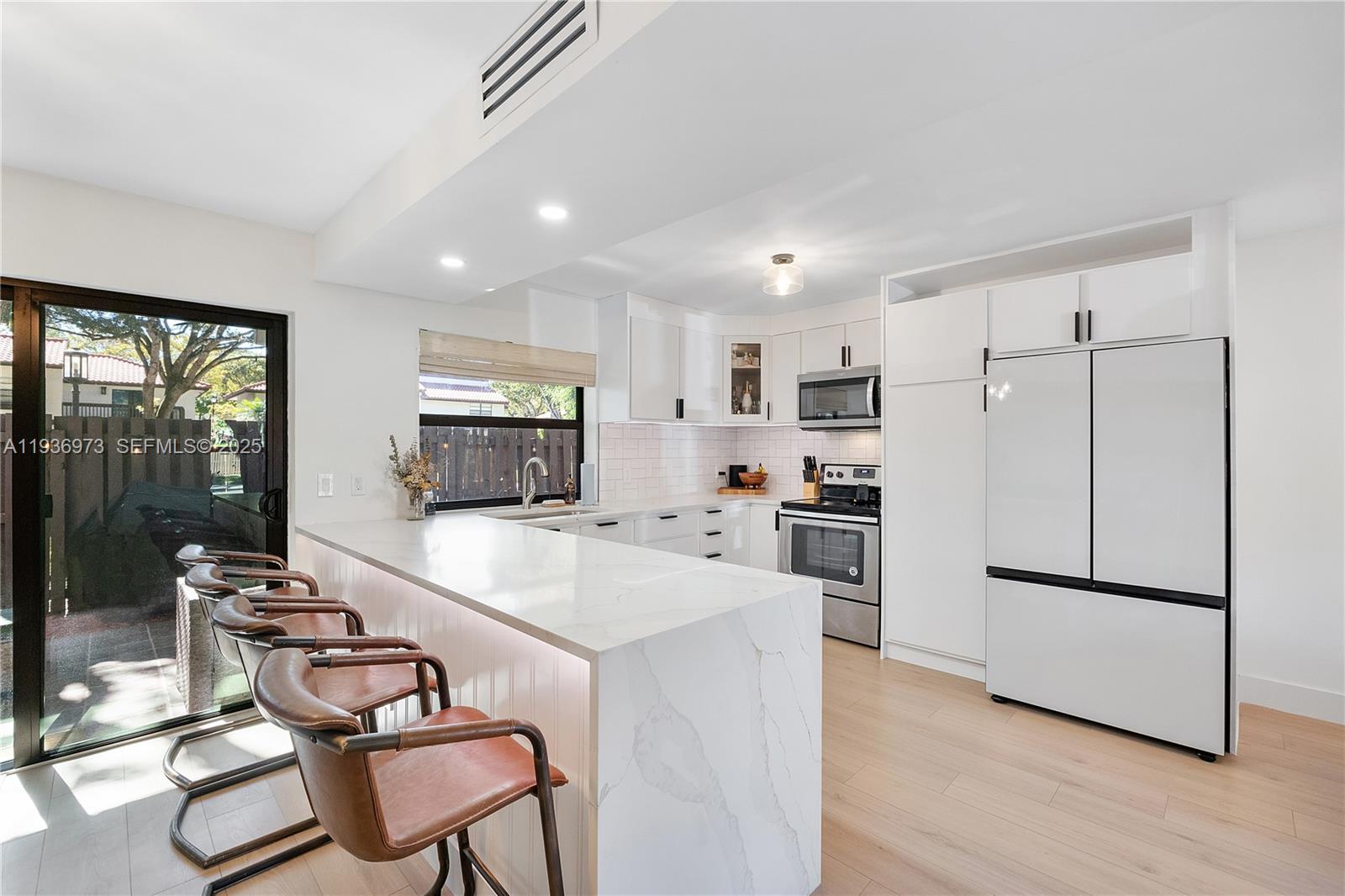 13234 Southwest 111th Terrace, Unit 44 Miami, FL 33186 - Photo 15 of 29 a kitchen with a refrigerator a stove top oven a sink dishwasher and white cabinets with wooden floor