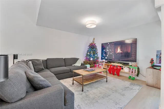 a living room with fireplace furniture and a large window