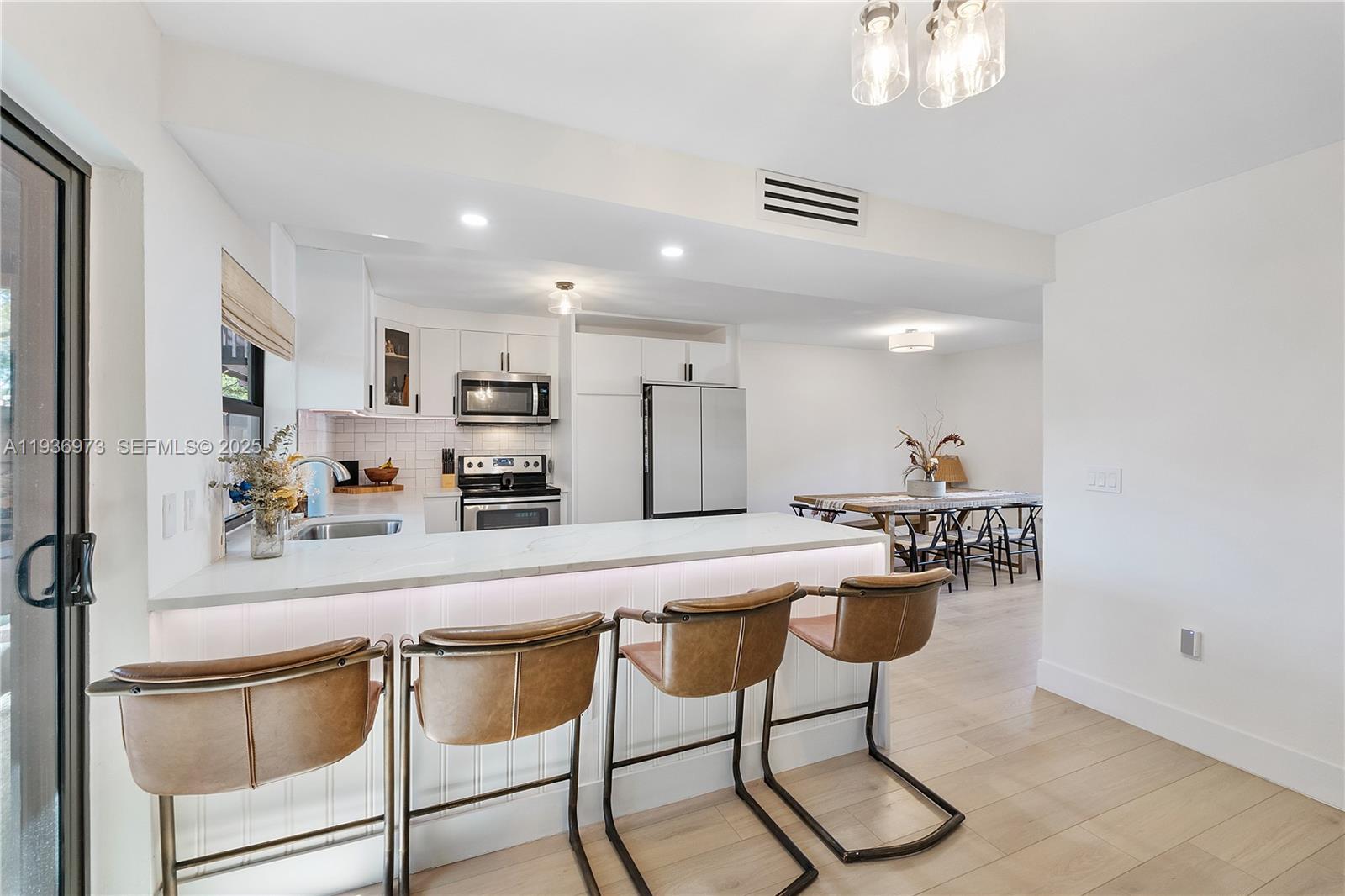 13234 Southwest 111th Terrace, Unit 44 Miami, FL 33186 - Photo 2 of 29 a kitchen with stainless steel appliances granite countertop a sink a stove a refrigerator with white cabinets and wooden floor