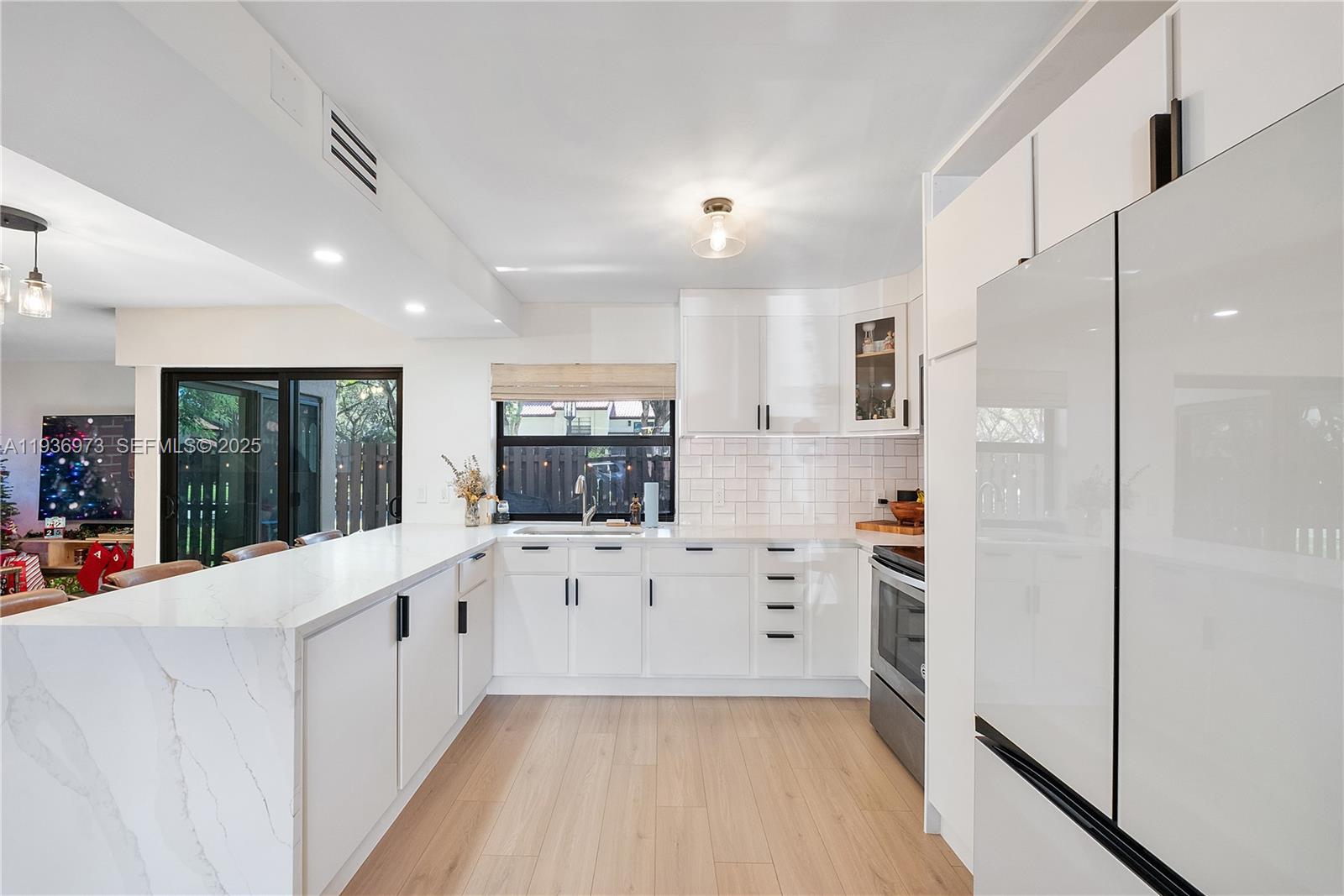 13234 Southwest 111th Terrace, Unit 44 Miami, FL 33186 - Photo 4 of 29 a kitchen with white cabinets and stainless steel appliances