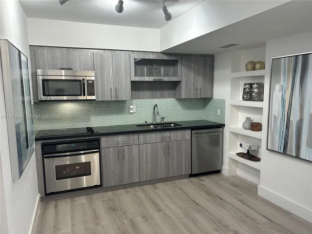 a kitchen with granite countertop a refrigerator and a stove top oven