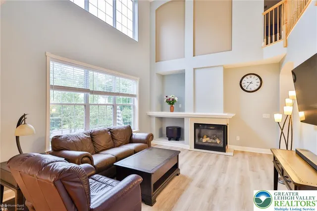 a living room with furniture a fireplace and a large window