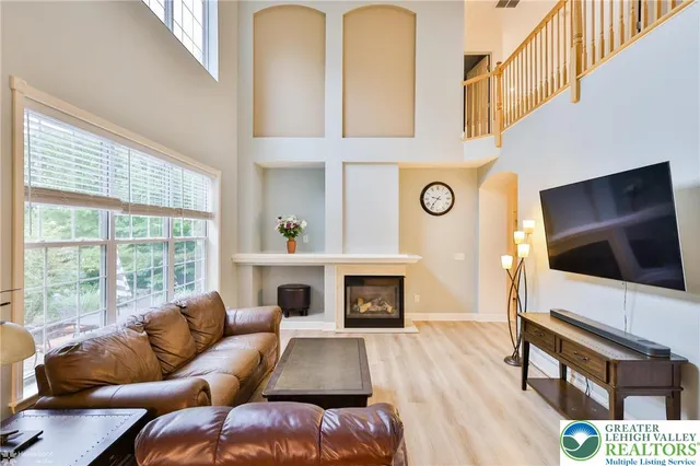 a living room with furniture a flat screen tv and a fireplace