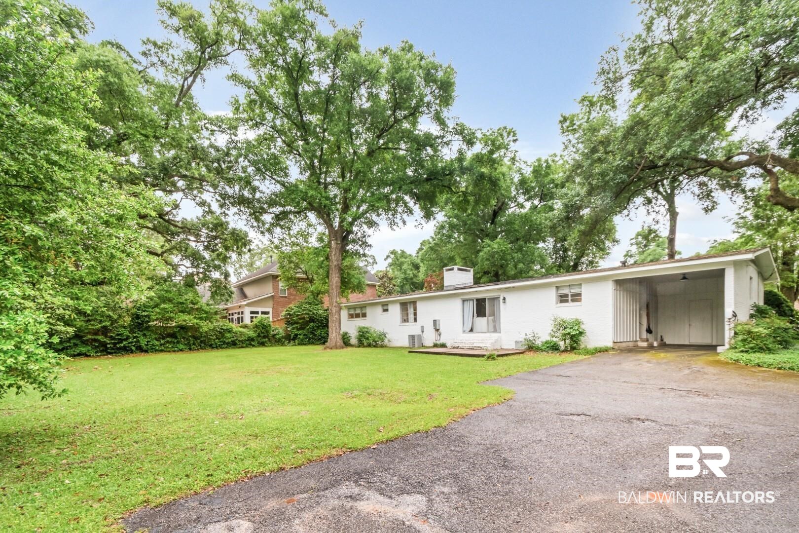 4596 Hawthorne Place Mobile, AL 36608 - Photo 27 of 34 Single-story residence featuring a white exterior, a covered carport, and a paved driveway