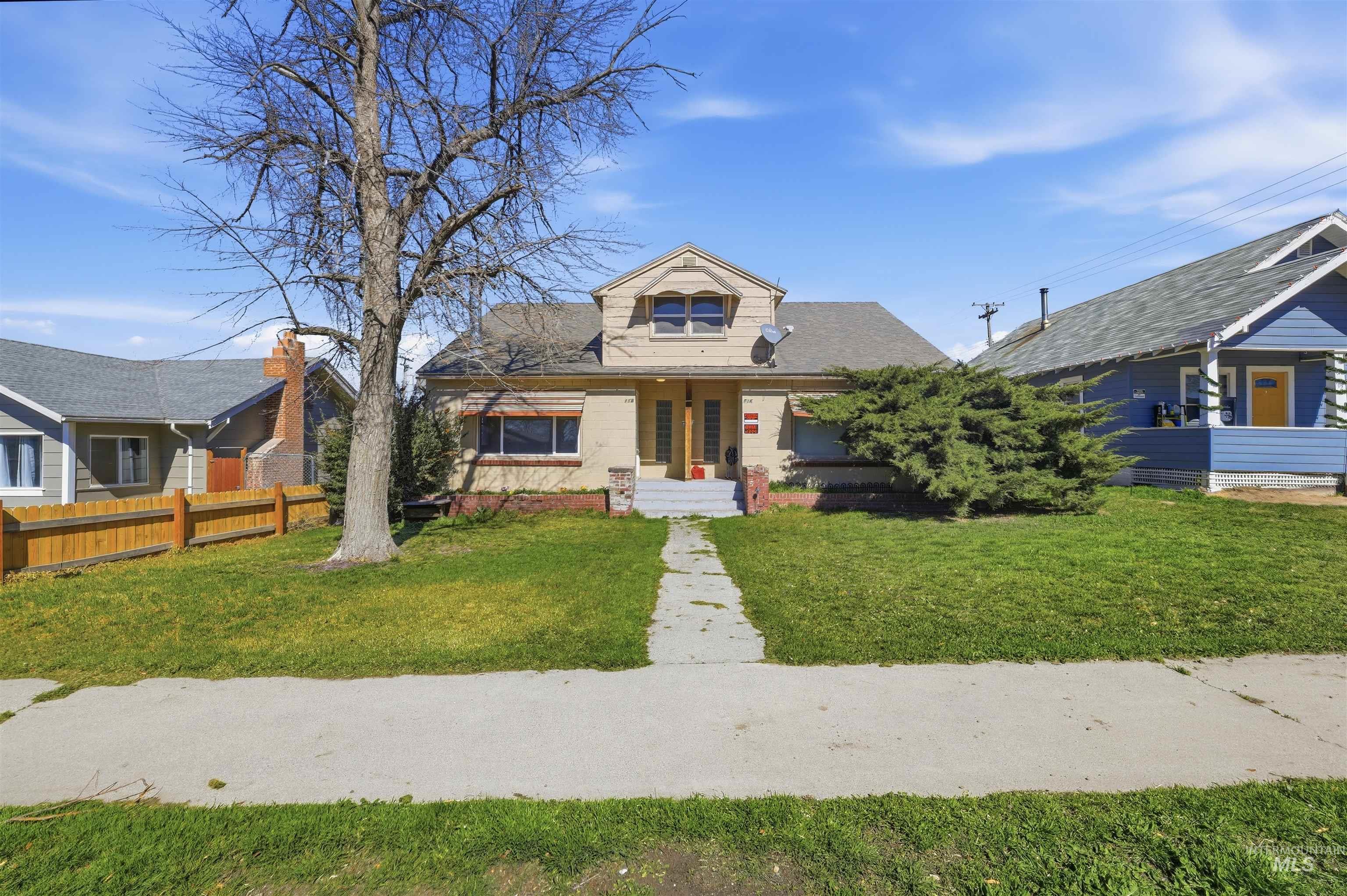 Bungalow-style house with a front lawn, a porch, brick siding, and a shingled roof