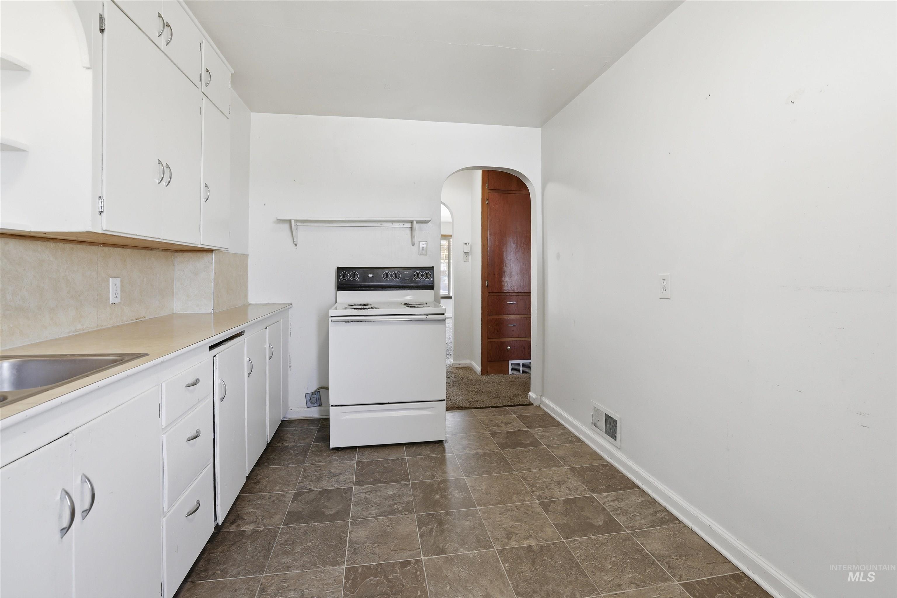 116 13th Avenue North Buhl, ID 83316 - Photo 13 of 37 Kitchen with white cabinets, light countertops, white electric range oven, stone finish flooring, and open shelves