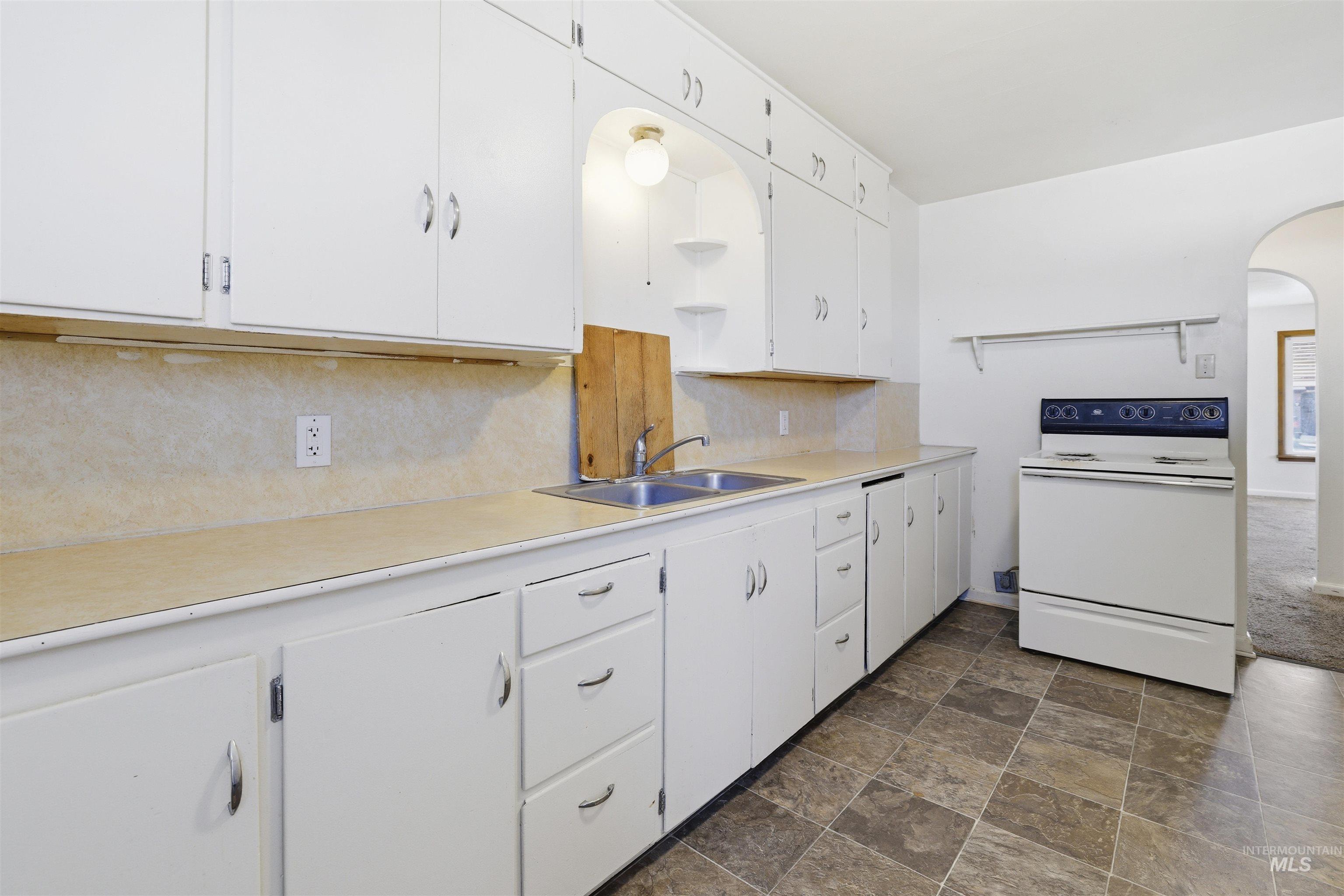 116 13th Avenue North Buhl, ID 83316 - Photo 14 of 37 Kitchen featuring arched walkways, white cabinets, white electric range oven, open shelves, and stone finish floors