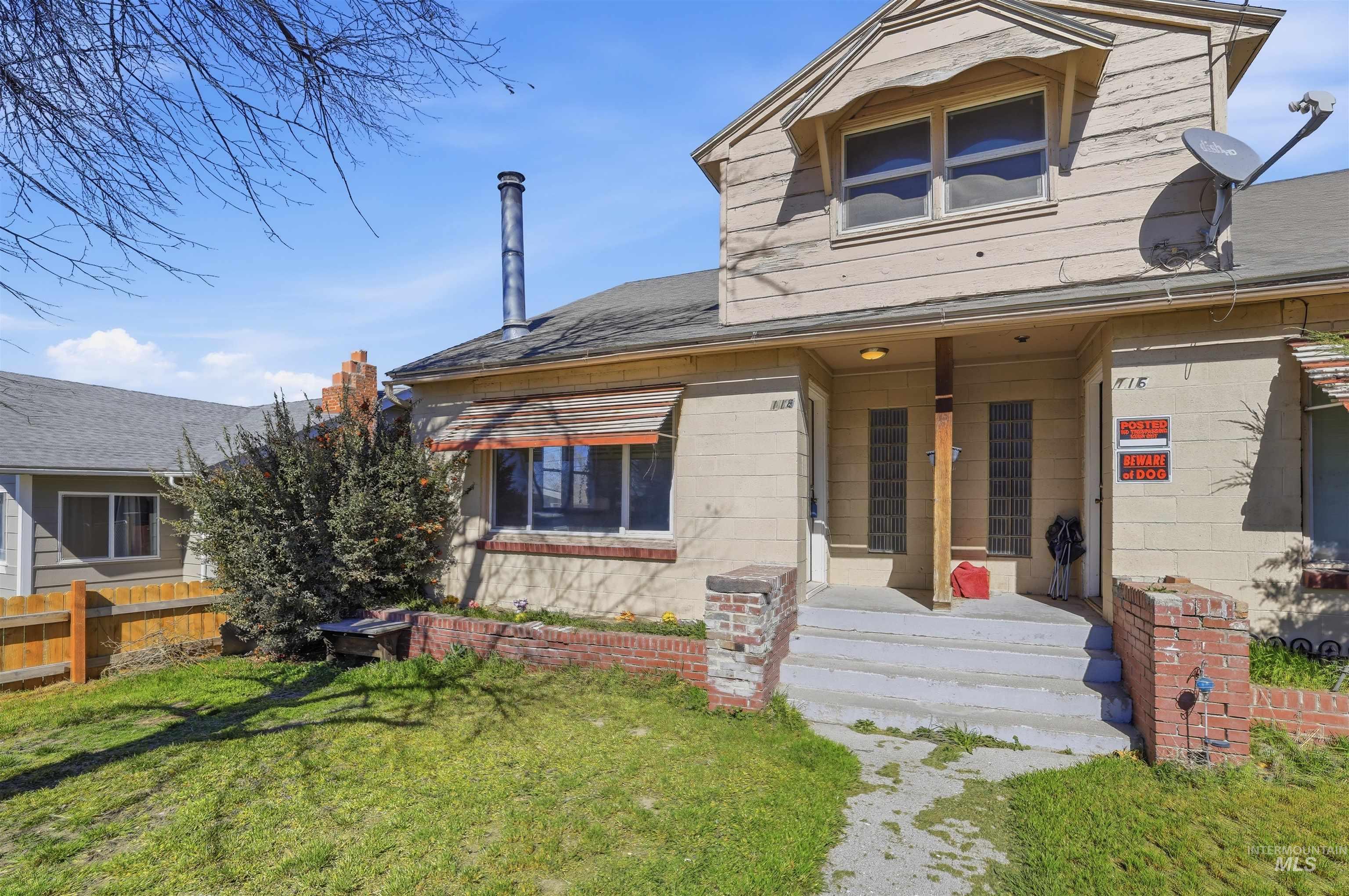 116 13th Avenue North Buhl, ID 83316 - Photo 23 of 37 View of front of property with a porch, concrete block siding, a front yard, and a shingled roof