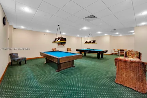 a living room with furniture pool table and a couch