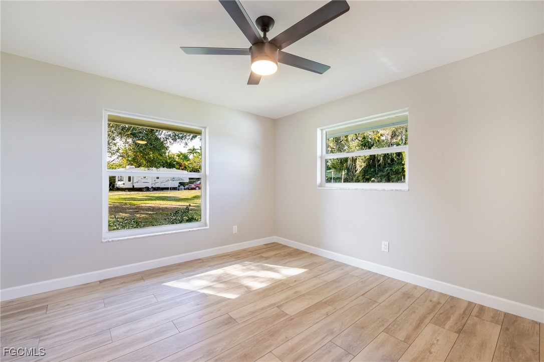 14502 Riverside Drive Fort Myers, FL 33905 - Photo 18 of 33 an empty room with wooden floor and windows