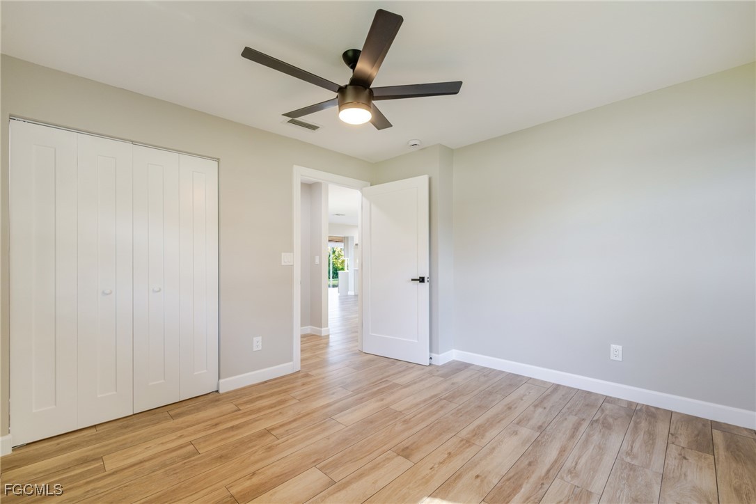 14502 Riverside Drive Fort Myers, FL 33905 - Photo 19 of 33 an empty room with wooden floor and windows