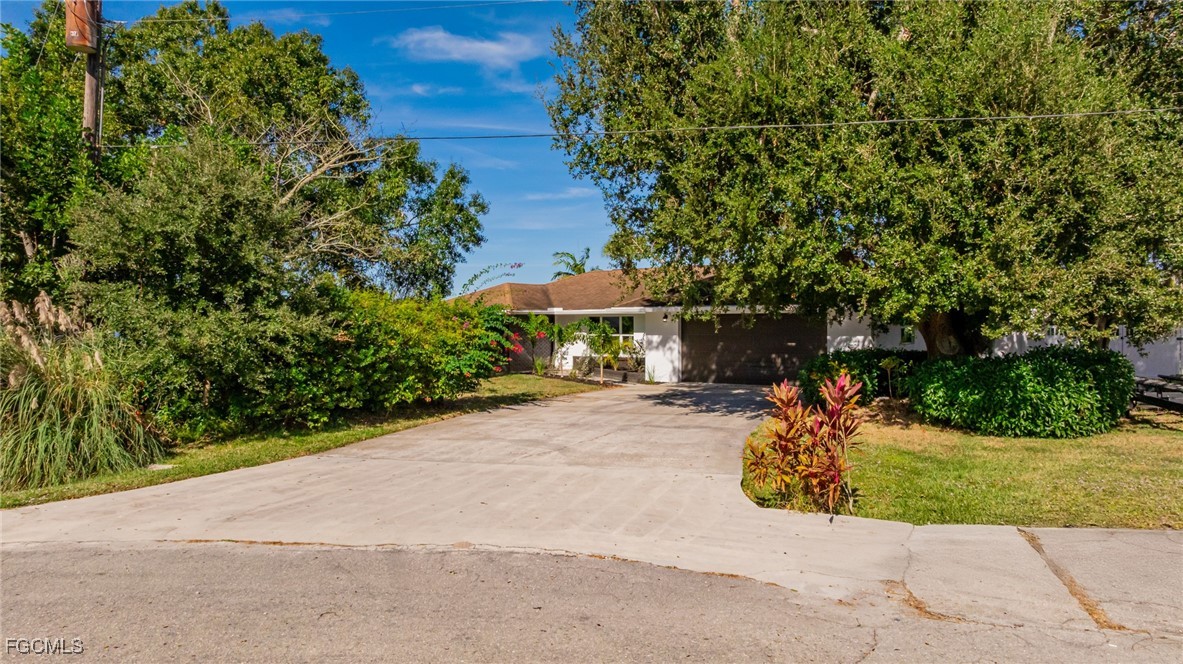 14502 Riverside Drive Fort Myers, FL 33905 - Photo 2 of 33 a view of a street with potted plants and large trees