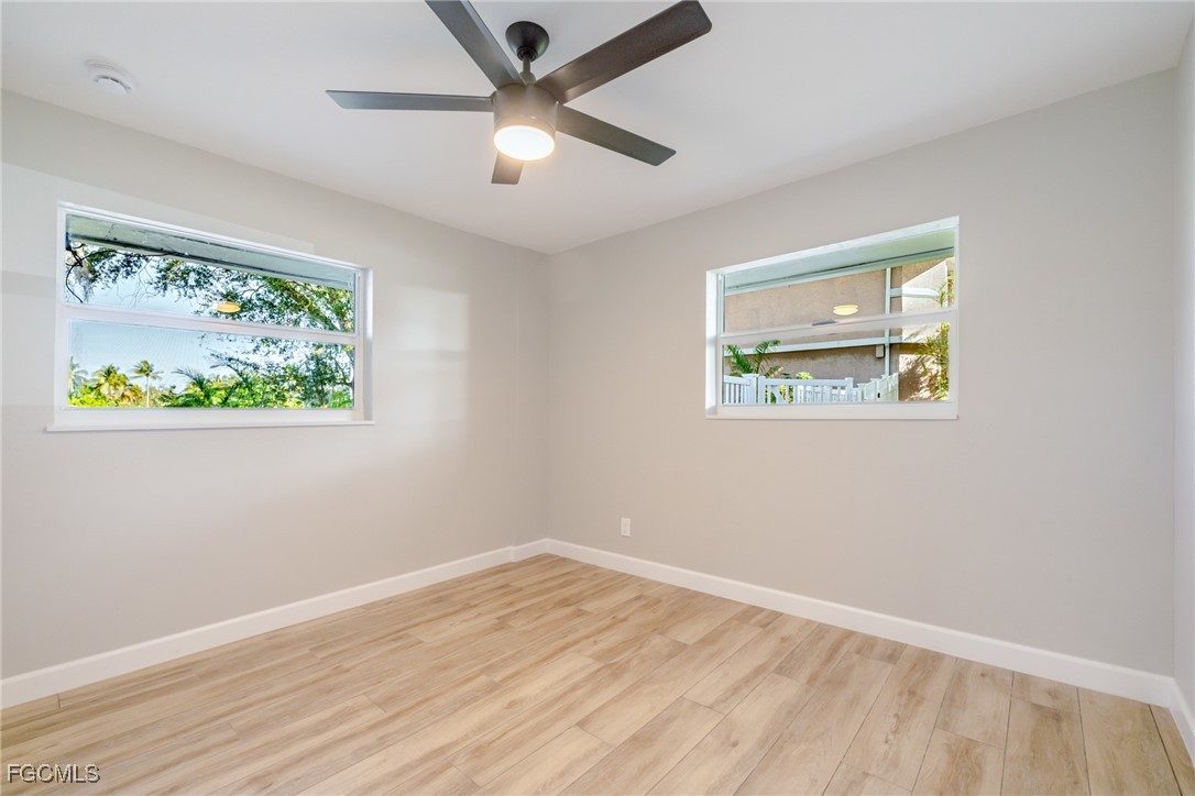 14502 Riverside Drive Fort Myers, FL 33905 - Photo 21 of 33 a view of an empty room with wooden floor and a window